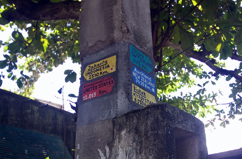052043IMG_0186_pn.jpg - Part of a local education project on Apo Island, signs like these, showing the distance to places in the world, can be found around the village.